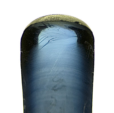Curved banding as seen in a half boule of Verneuil synthetic corundum. Note that the curvature is greatest at the outside edges. Photo: Richard W. Hughes, Lotus Gemology