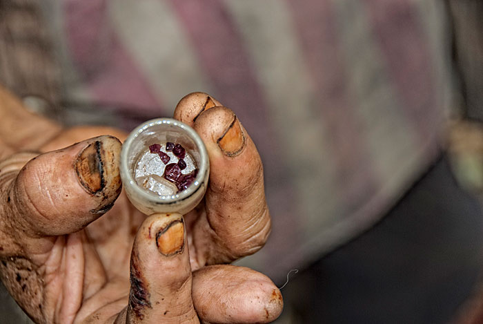 A handul of rubies, along with a piece of quartz from Thailand's last ruby miner.