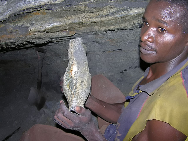 A young Kenyan miner collecting a tsavorite porphyroblast about 20 meters underground in the Tsavo area. Photo: J.B. Senoble, 2005.